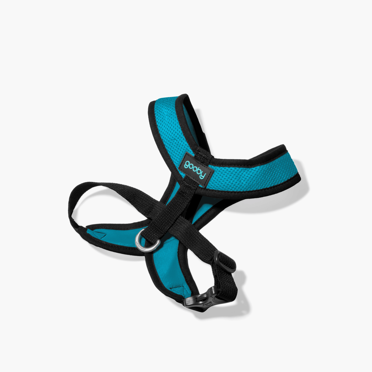 Turquoise Comfort X harness with black straps shown at an angle on a white floor