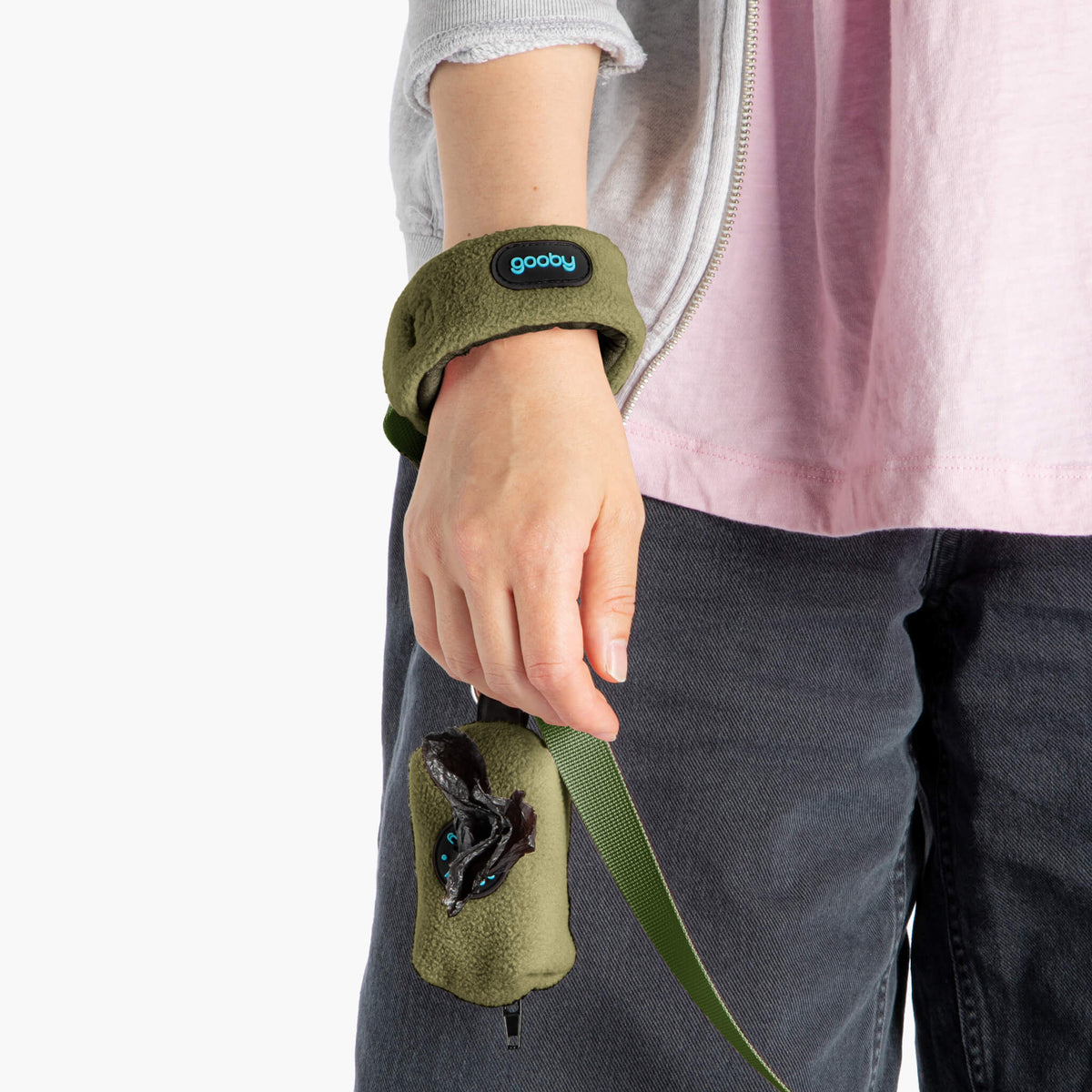 Close-up of a person wearing an olive fleece wristband leash with a matching treat pouch