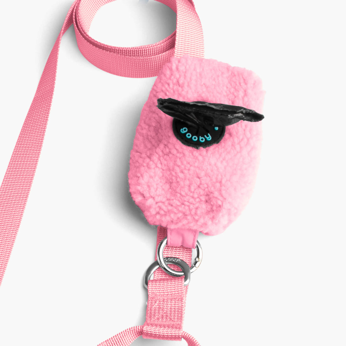 Close-up of a baby pink sherpa leash attachment with metal rings and black branding