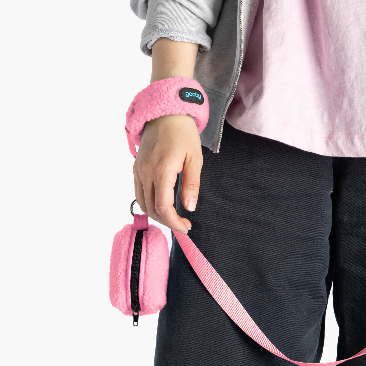 Close-up of a baby pink sherpa wristband leash with matching zippered pouch
