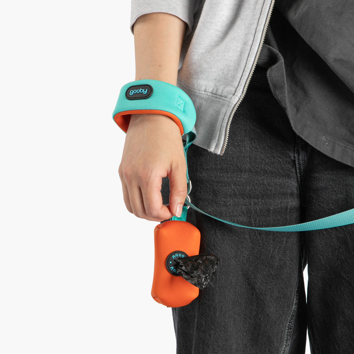 Close-up of a mint wristband leash with orange traffic handle worn by a person