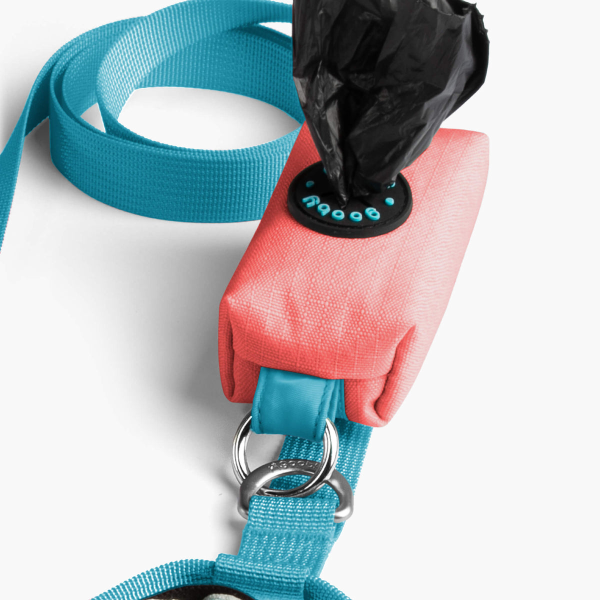 Close-up of a solid pink step-in harness with a turquoise matching leash and metal rings