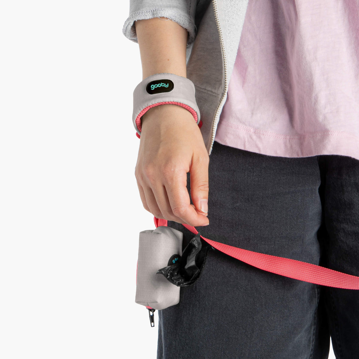 Close-up of a pink matching leash with a gray wrist strap and attached treat pouch