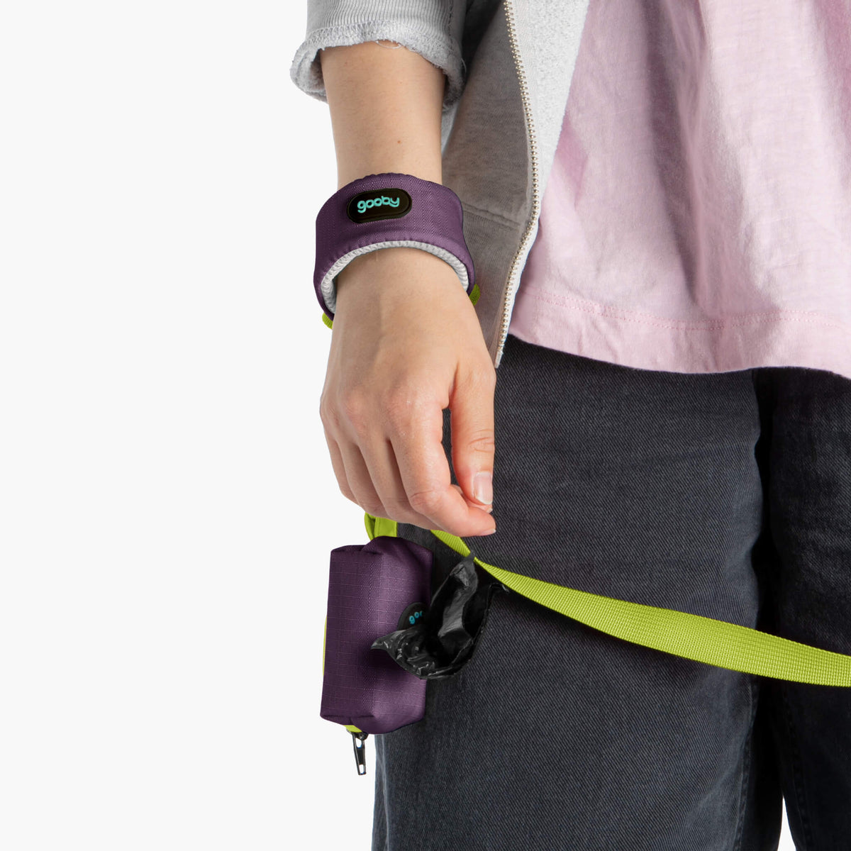 Close-up of a purple wristband leash pouch and neon green leash strap on a person