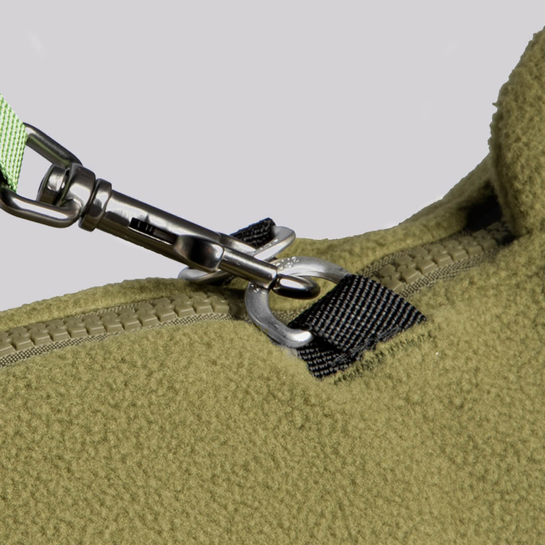 Close-up of a fleece vest zipper and metal pull with black webbing detail