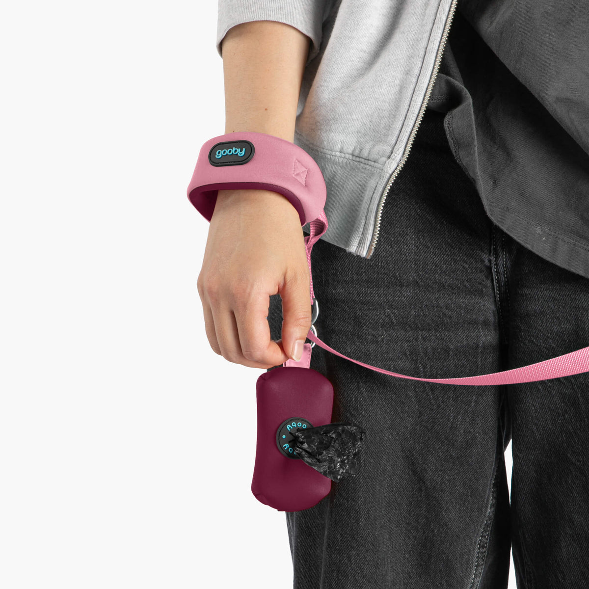 Close-up of a baby pink wristband leash with matching leash and waste bag holder