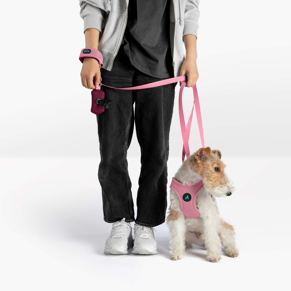 Person and dog wearing a pastel baby pink matching harness, leash, and wristband set