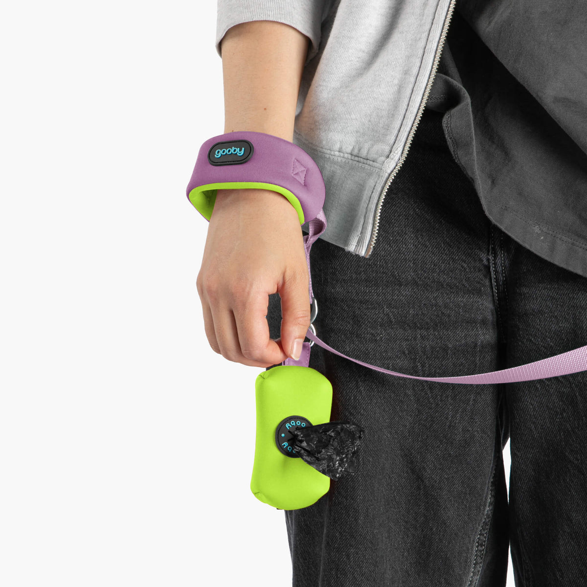 Close-up of a lavender wrist leash with a purple wristband and bright green accessory pouch
