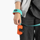 Close-up of a mint wristband leash with orange traffic handle in use