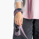 Close-up of a person wearing a lavender fleece wristband leash and matching accessory pouch.