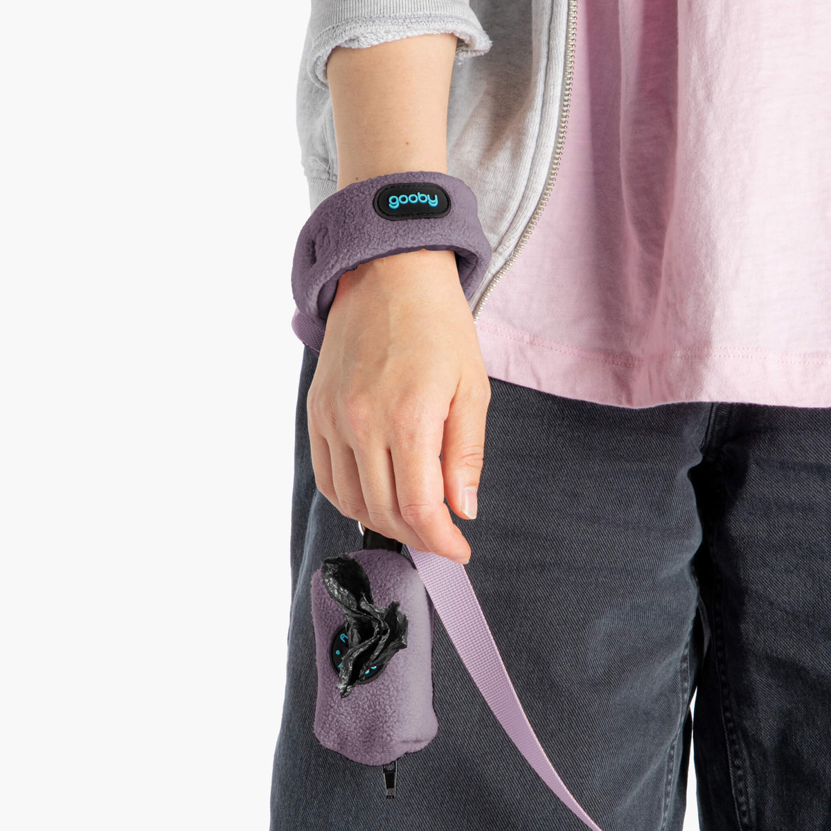 Close-up of a person wearing a lavender fleece wristband leash and matching accessory pouch.