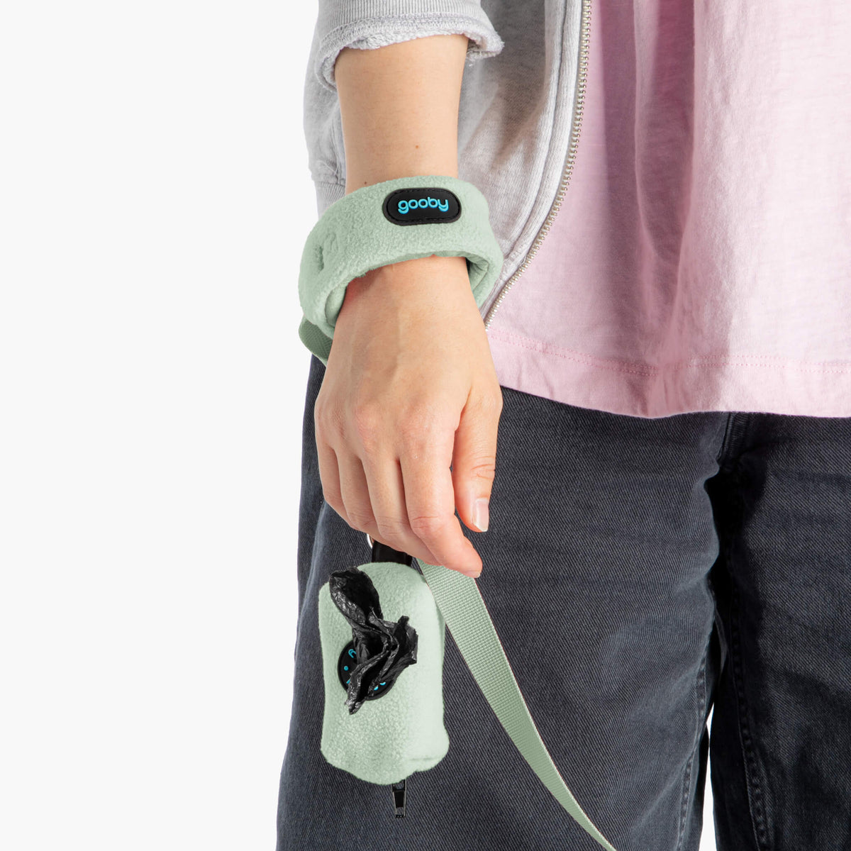 Close-up of a mint fleece matching leash set worn around a person's wrist