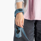 Close-up of a person wearing a blue fleece wristband with an attached matching leash