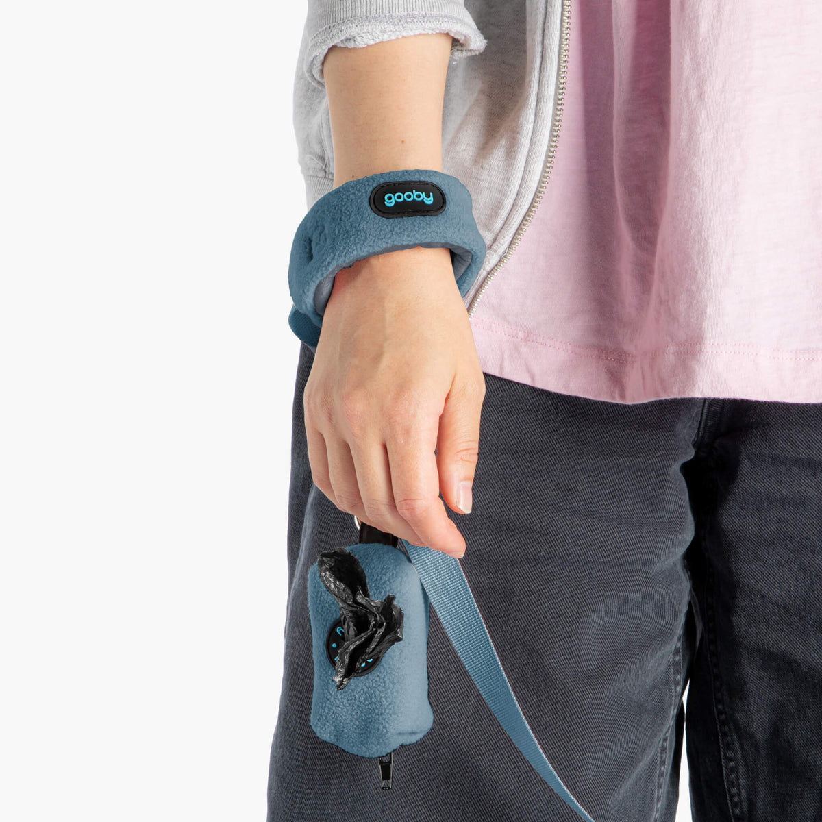 Close-up of a person wearing a blue fleece wristband with an attached matching leash