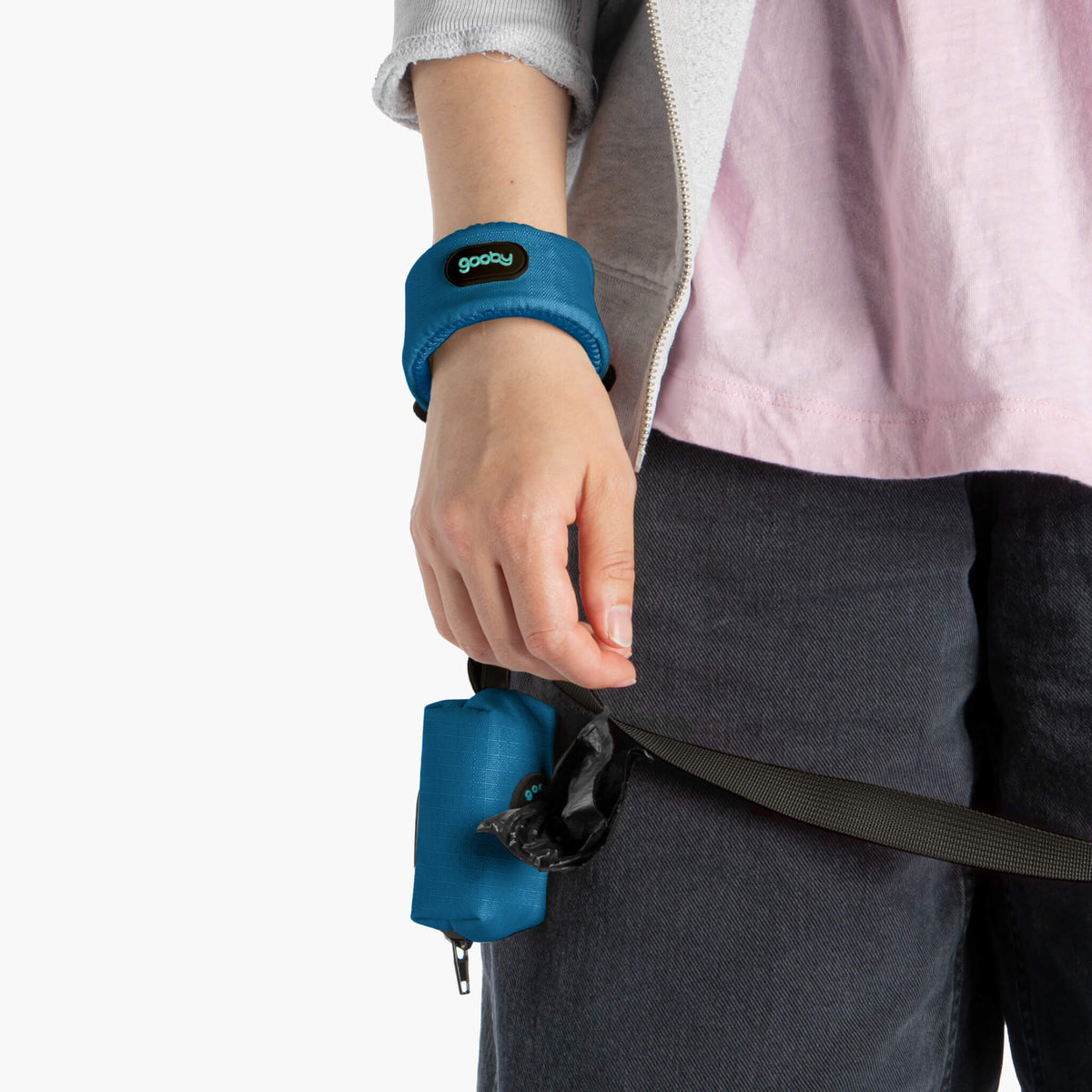 Close-up of a blue wristband leash worn on a person's wrist, with the leash handle hanging below
