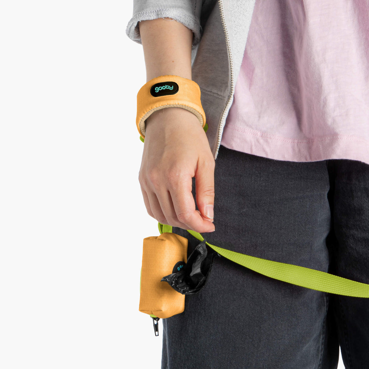 Close-up of an orange wristband leash worn on a person’s wrist, with the leash extending outward.