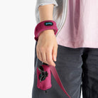 Close-up of a magenta wristband leash worn with a matching leash pouch
