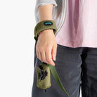 Close-up of an olive wristband and matching leash attached to a fleece vest