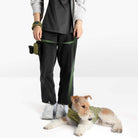 Dog wearing an olive fleece vest beside a person holding the matching green leash