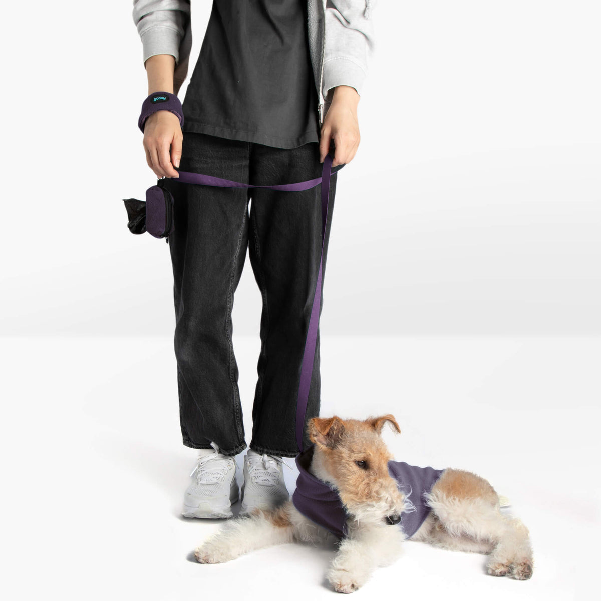 Person and wire-haired dog wearing matching purple fleece accessories